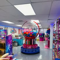 Gertrude, a giant gumball machine, in the middle of the Sugar Shenanigans shop
